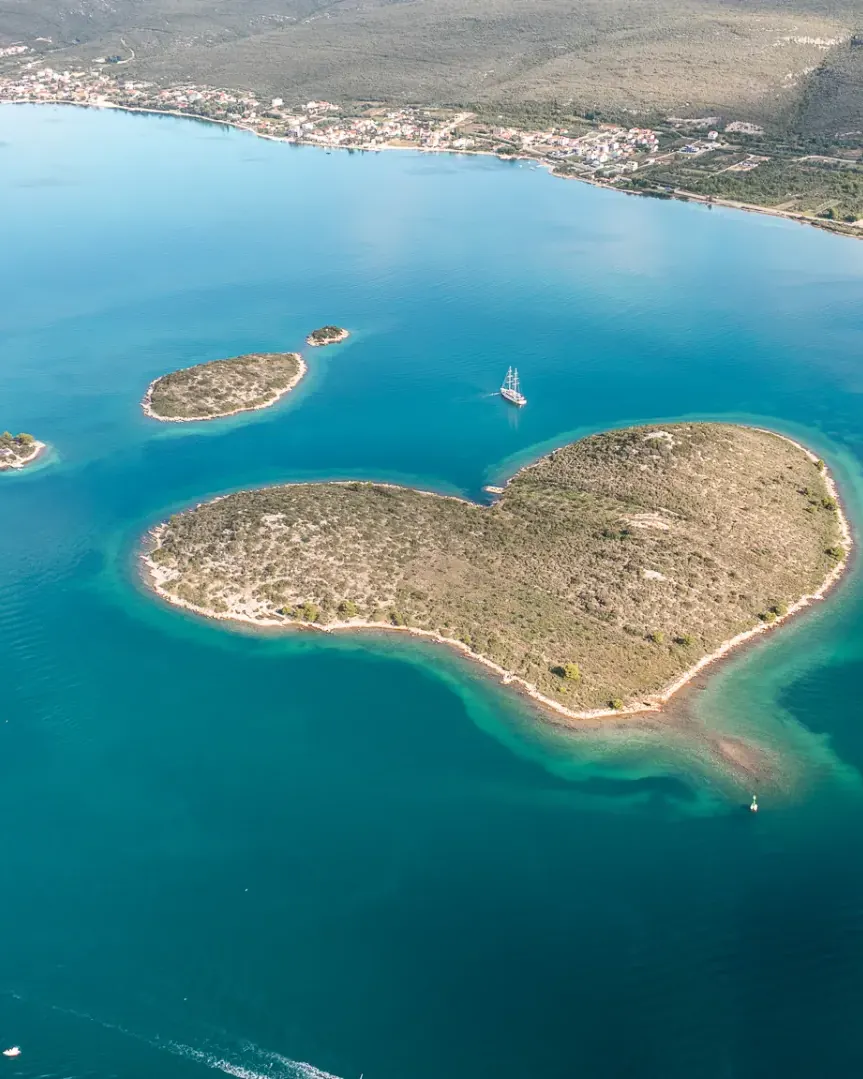 Een hartvormig eiland in turquoise water voor de Kroatische kust
